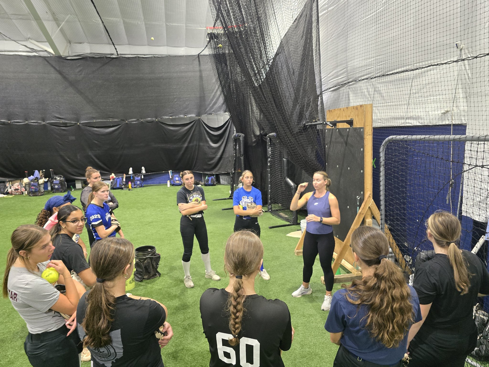 Lake Erie Vengeance players gathered around Jessie Harper during clinic instruction