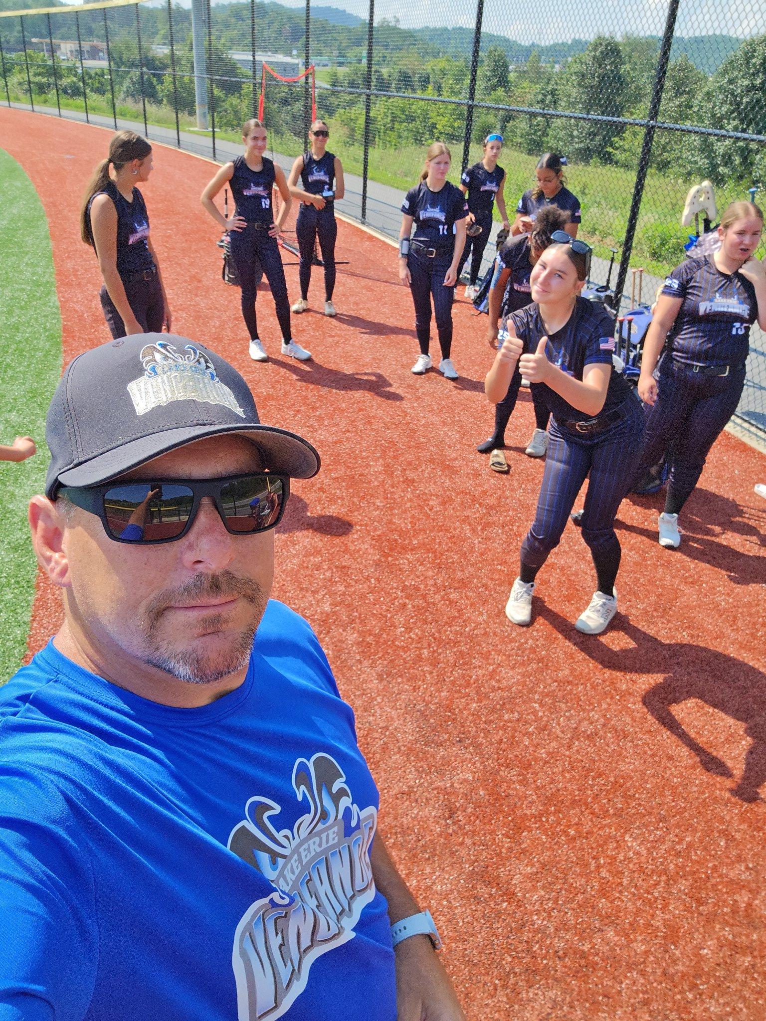Lake Erie Vengeance coach taking a selfie with players on the field behind him